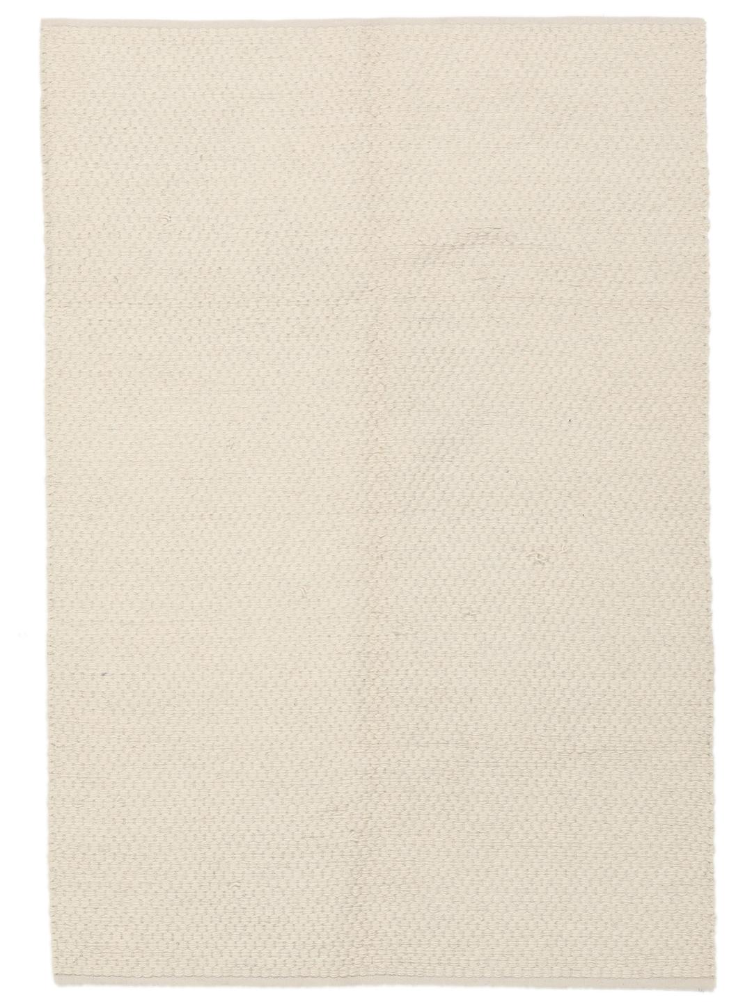 En minimalistisk, beige handvävd matta från Indien med en ren, texturerad yta.