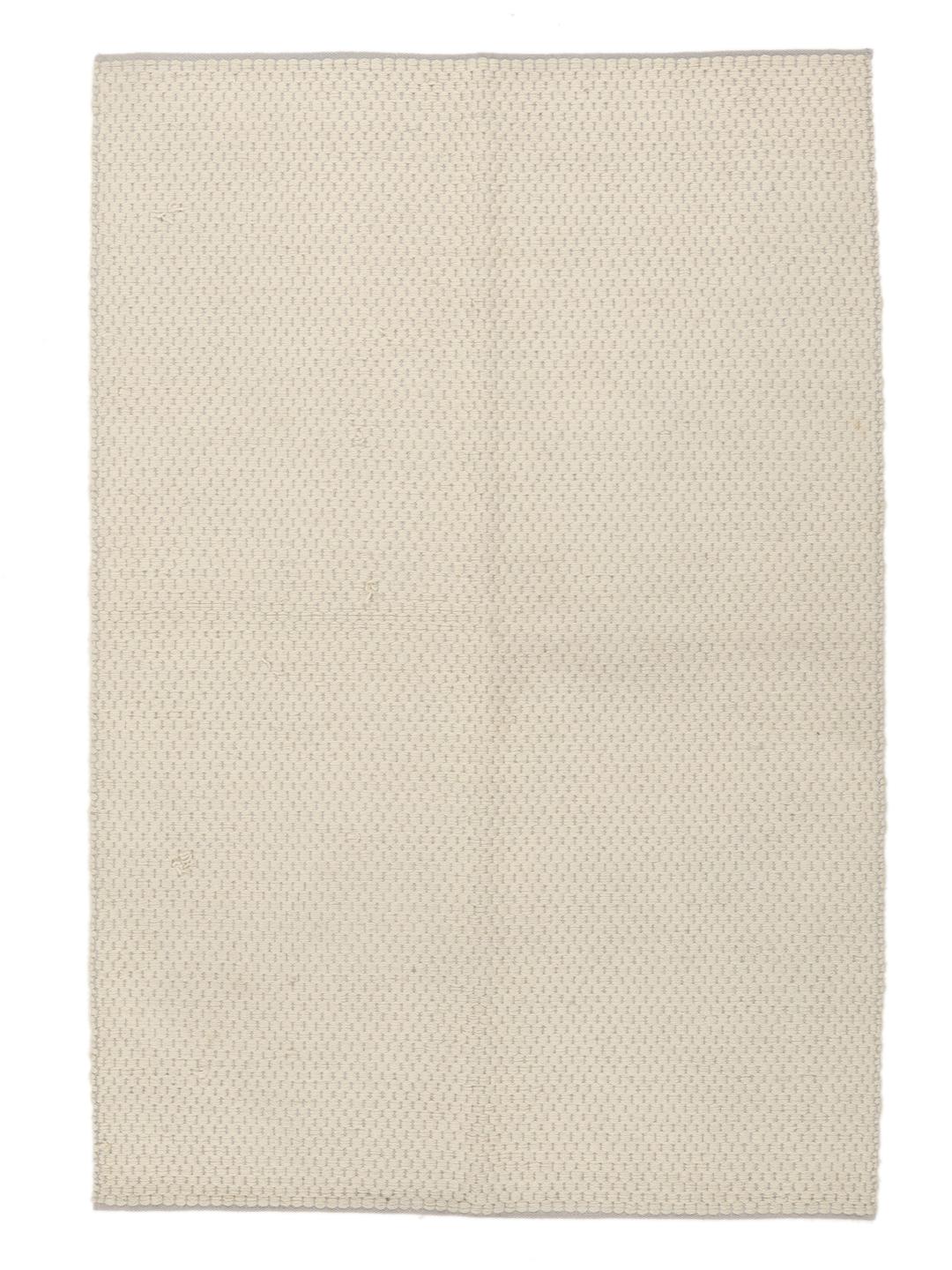 Een minimalistisch handgeweven vloerkleed uit India in een zachte beige tint.