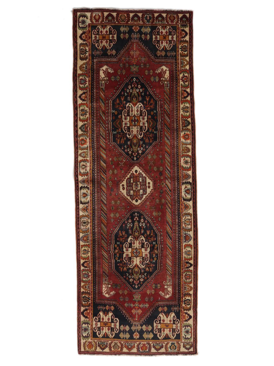 A hand-knotted, one-of-a-kind Qashqai runner rug with a deep red field and intricate geometric medallions.