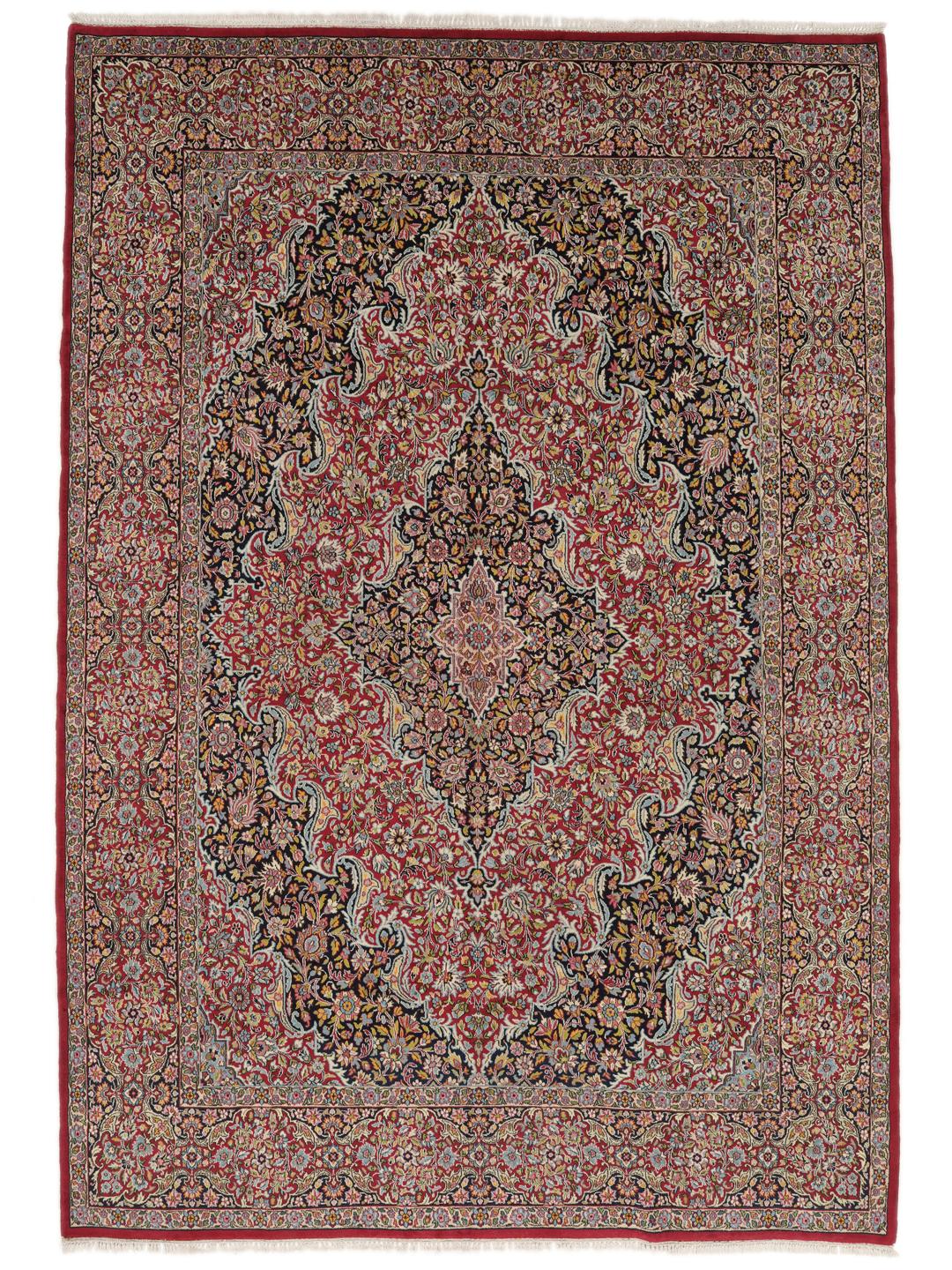 A hand-knotted Kerman rug with a floral medallion design in red and dark tones.