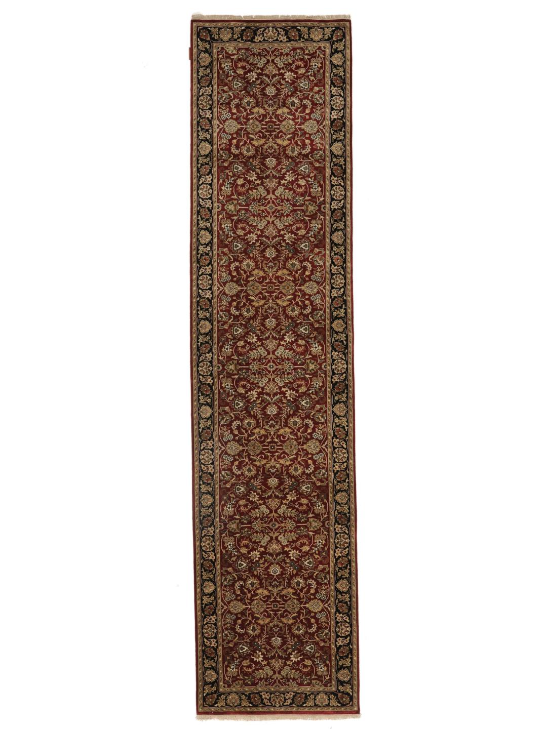Un covor tip runner indian înnodat manual cu un câmp roșu și modele florale ornamentate