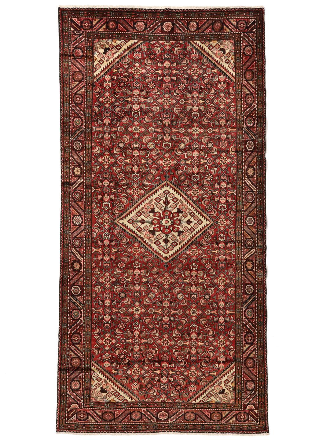Een handgeknoopt donkerrood Hosseinabad-tapijt met ingewikkelde geometrische patronen.