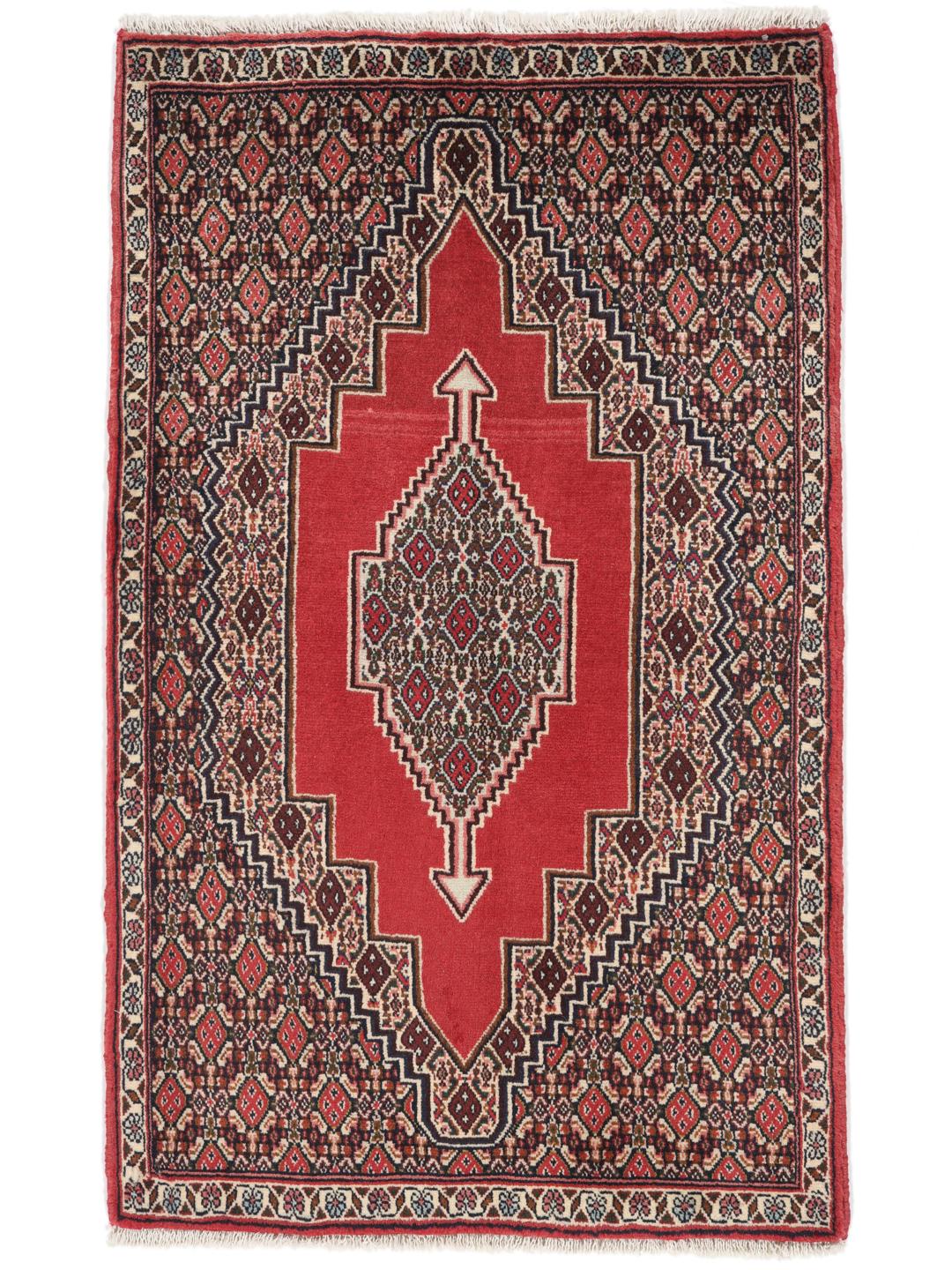A hand-knotted Senneh rug from the Middle East in red with geometric motifs.