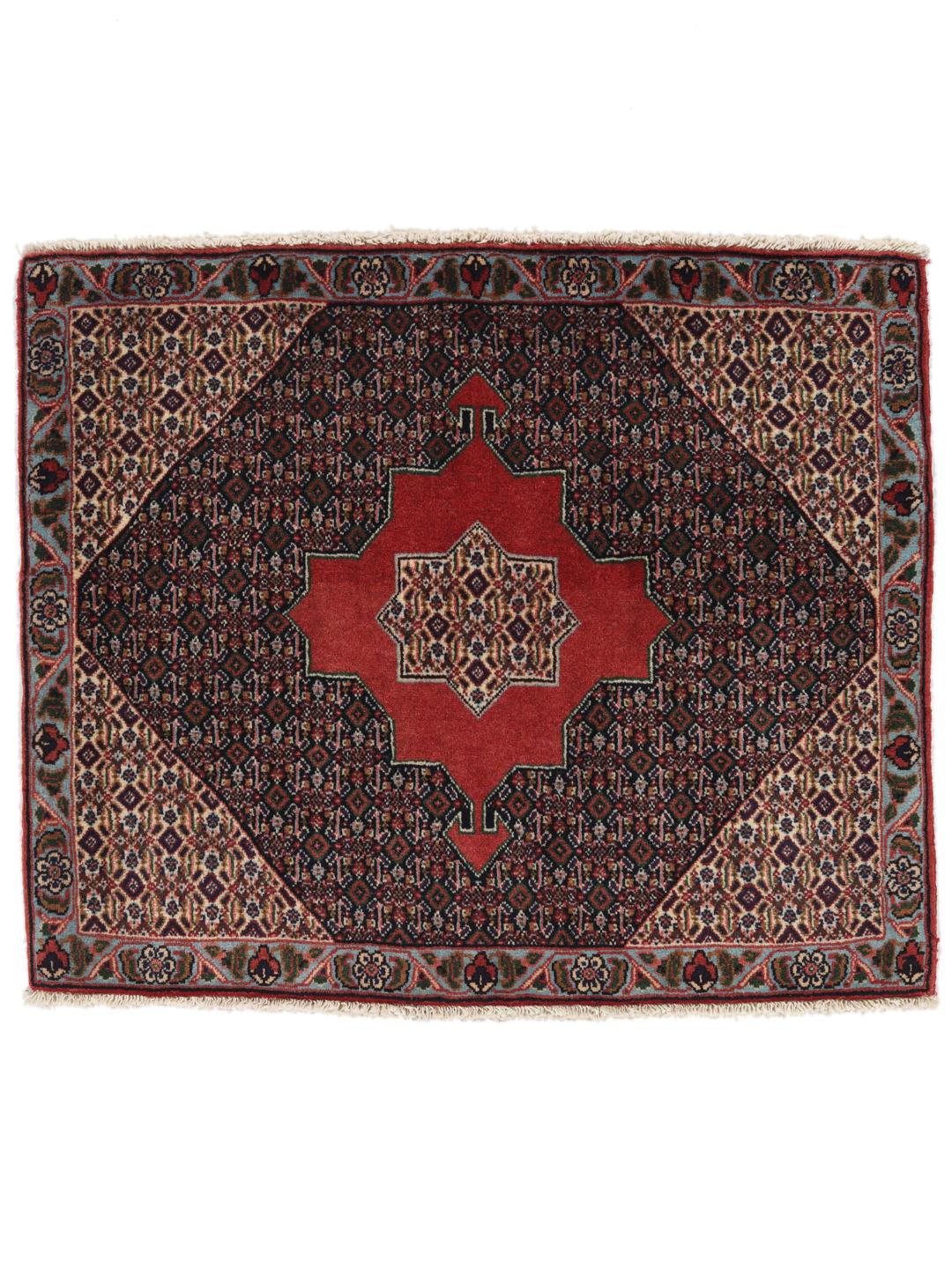 A hand-knotted Senneh rug from the Middle East featuring a red and dark-blue patterned design.