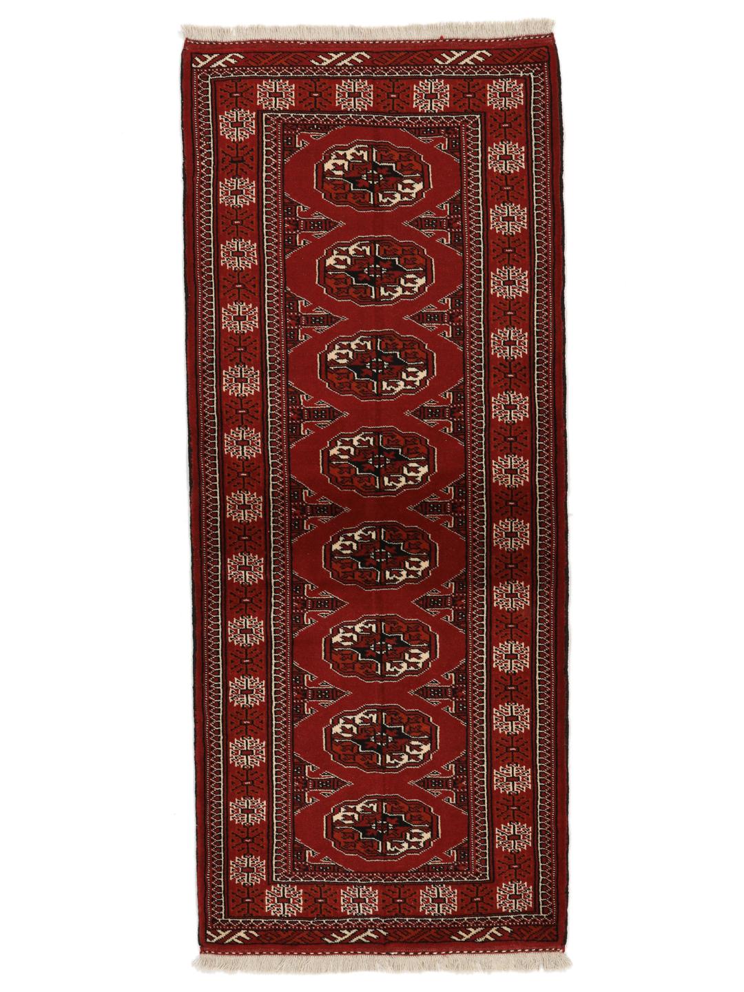 A hand-knotted Middle Eastern Turkaman runner in deep red with geometric medallion patterns.