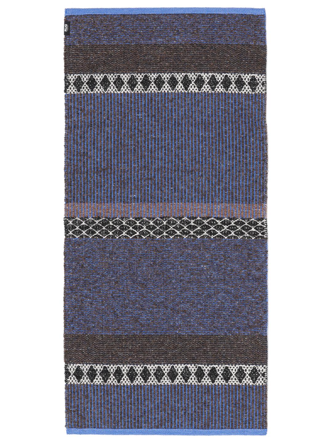 Een rechthoekig geweven tapijt in blauw en bruin met een herhalend geometrisch patroon.