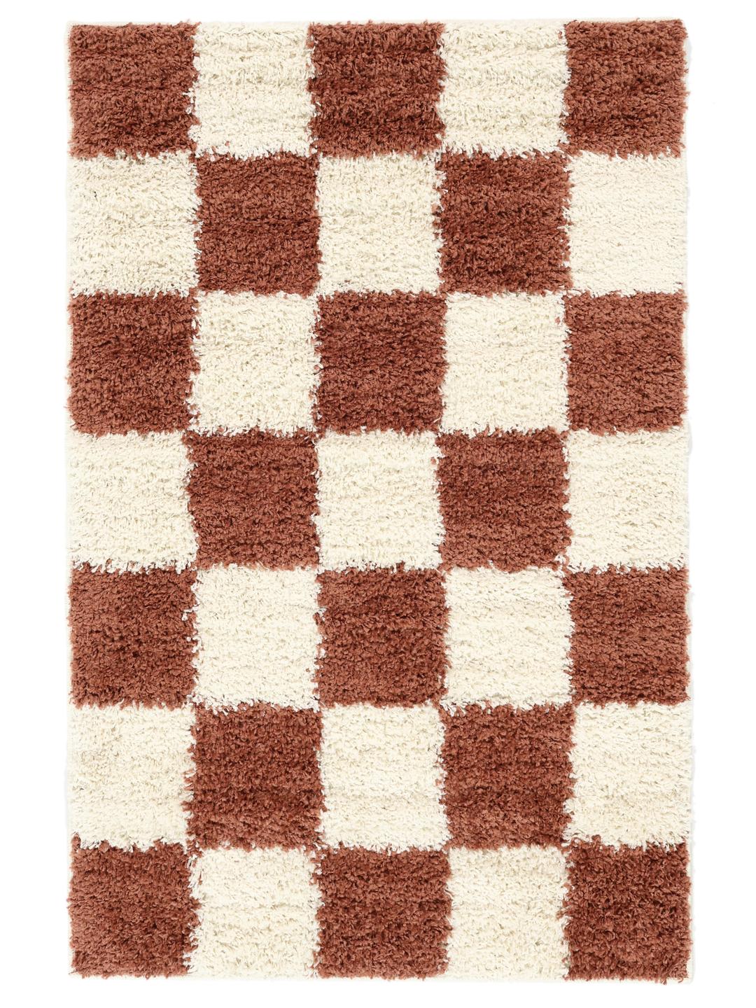 Roestrood en gebroken wit vloerkleed met een pluche geruit patroon.