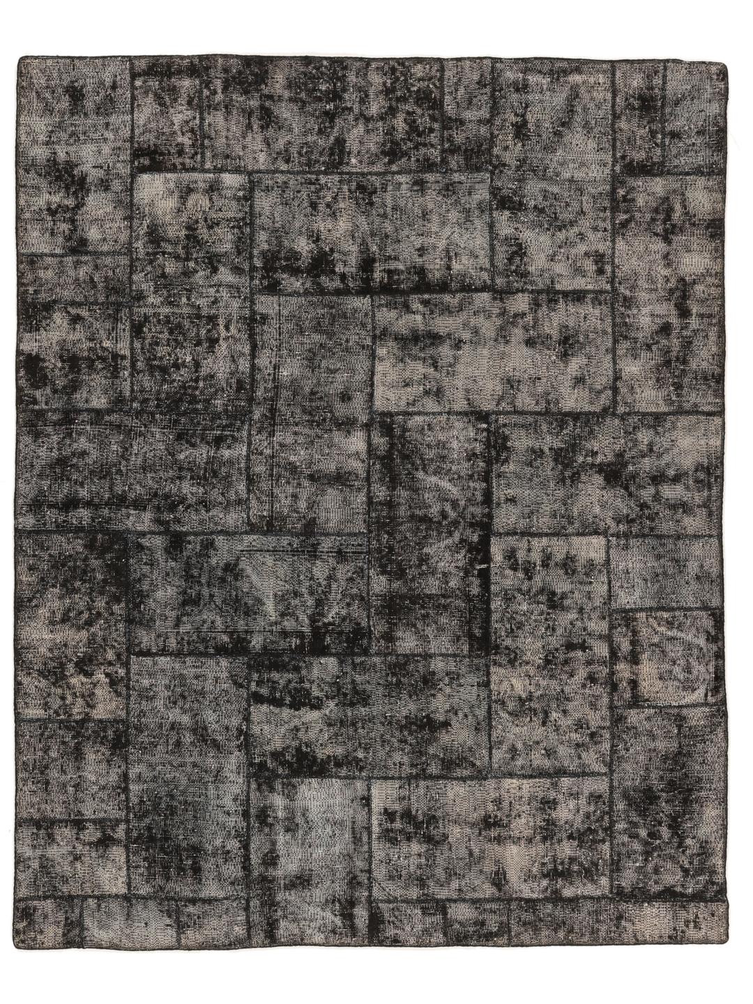Een groot rechthoekig patchwork vloerkleed uit Turkije met een verweerd zwart en grijs patroon.