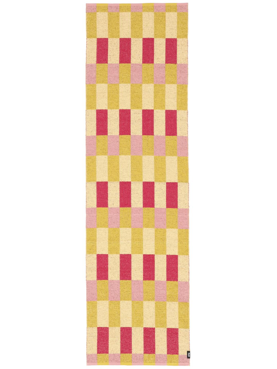 Een loper met een speels roze en geel geblokt patroon.