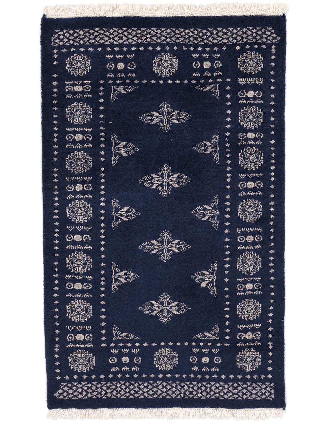 Hand-knotted wool rug from Pakistan in dark-blue with light-coloured geometric motifs.