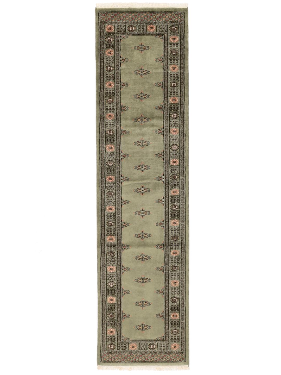 A long, hand-knotted Pakistan Bokhara runner rug in a soft sage green colour with repeating geometric motifs.