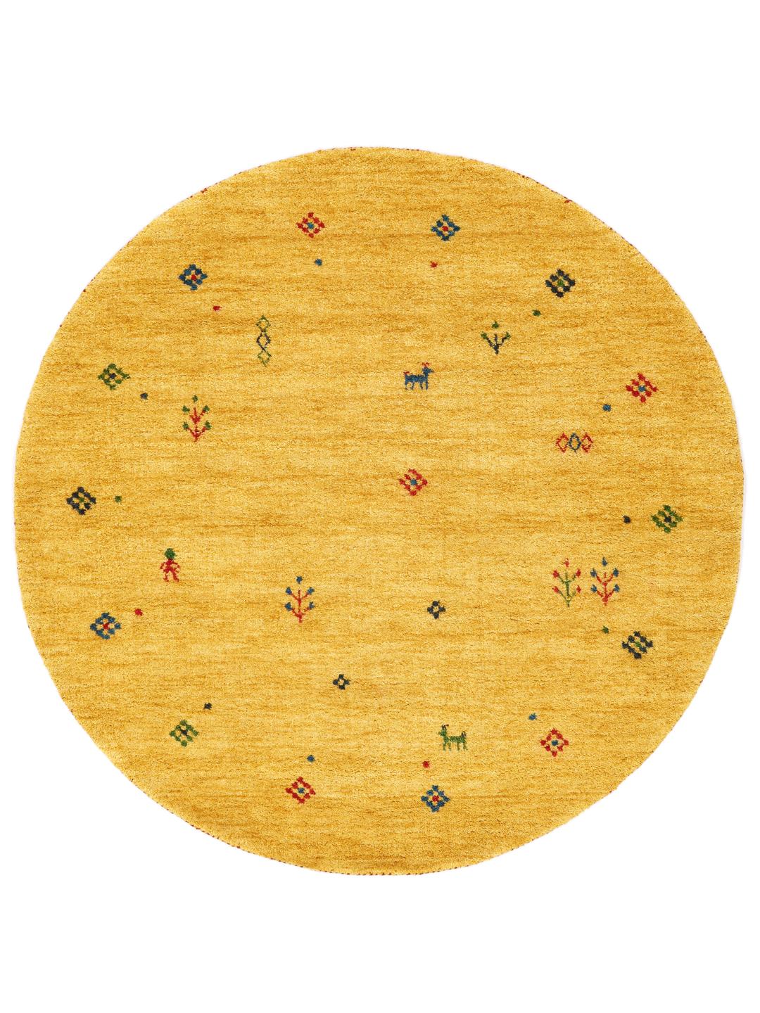 Rond geel tapijt met kleine kleurrijke motieven op een houten vloer