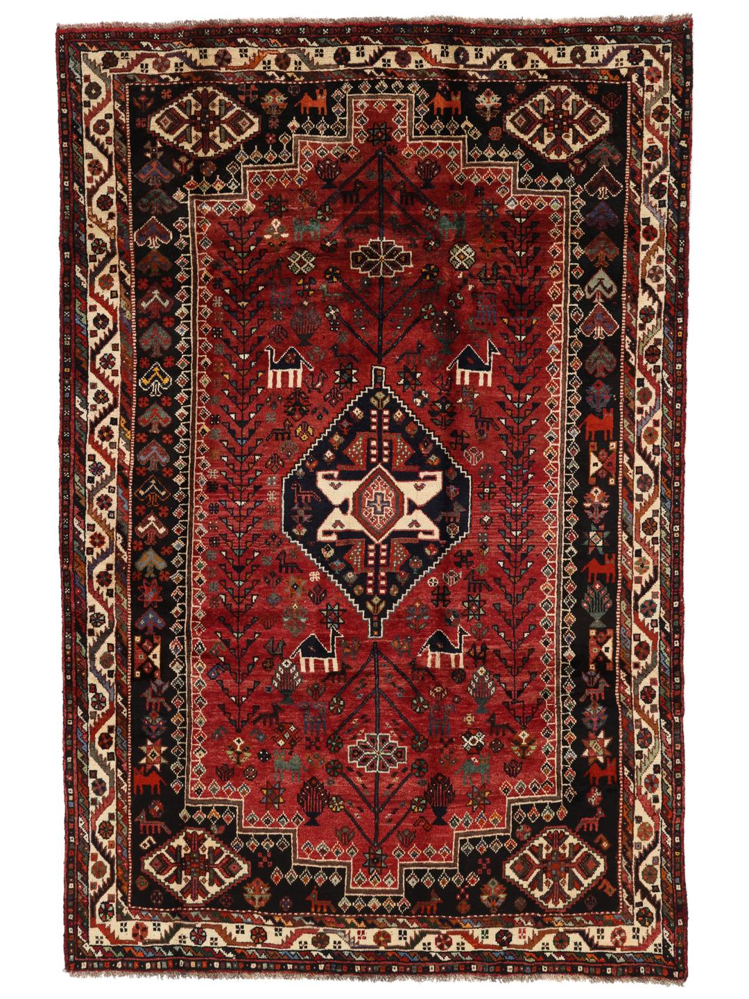 Hand-woven Shiraz rug from the Middle East featuring a vibrant red and black palette with tribal motifs