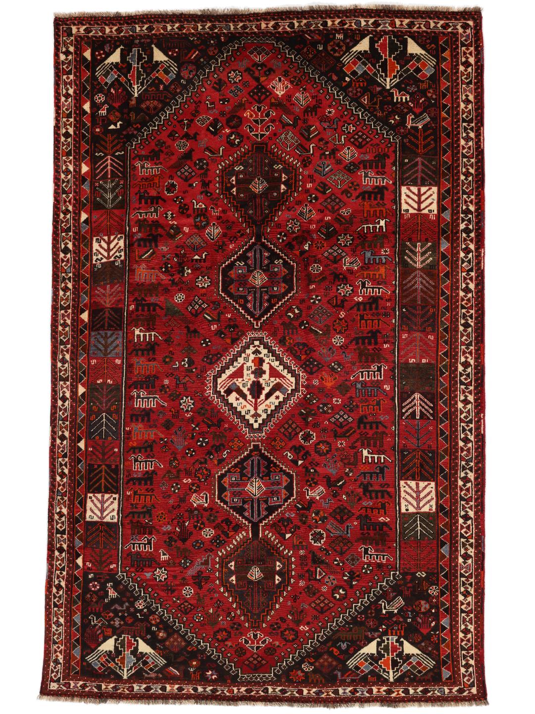 A beautiful hand-knotted Qashqai rug from the Middle East with a red field and traditional patterns.