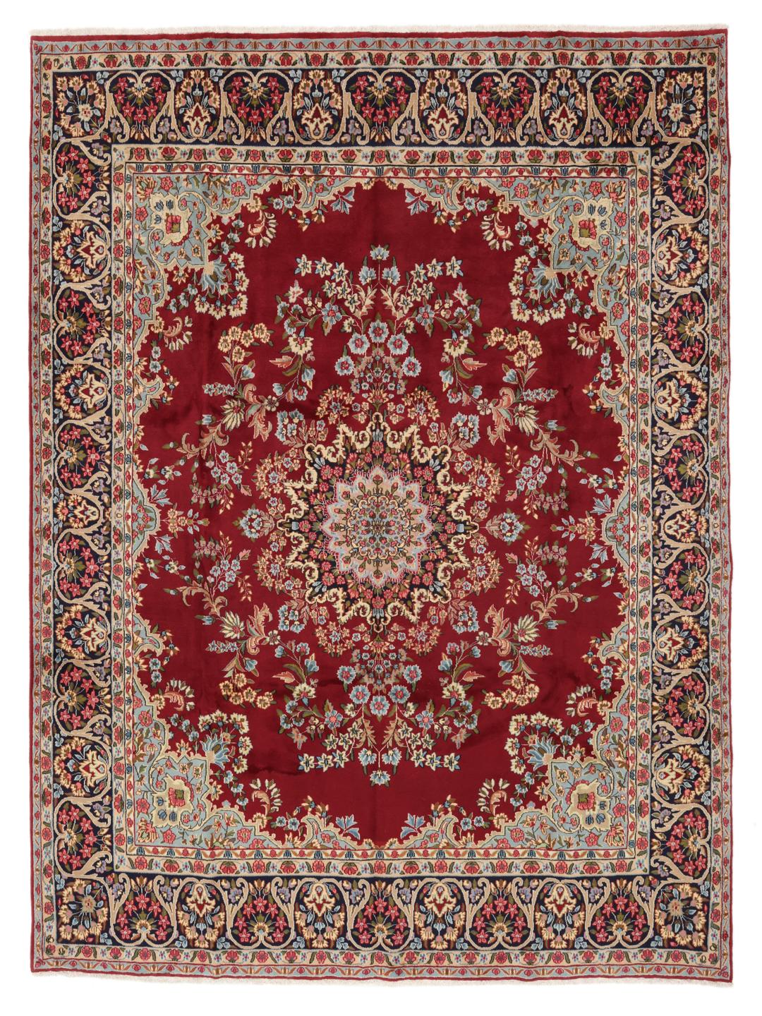 A hand-knotted Kerman rug with a large central floral medallion on a red field.