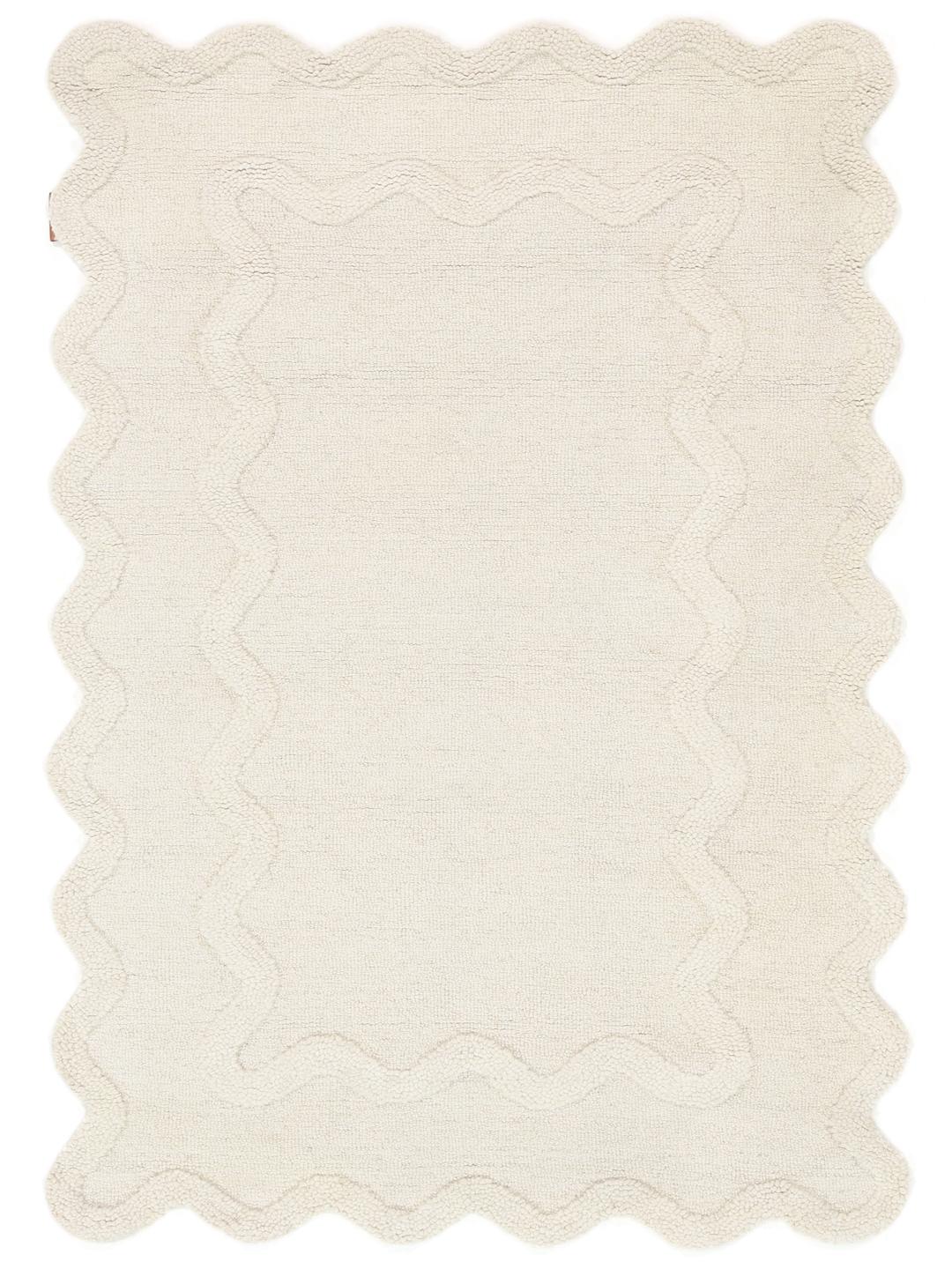 Tapis blanc cassé avec une surface texturée et un bord festonné