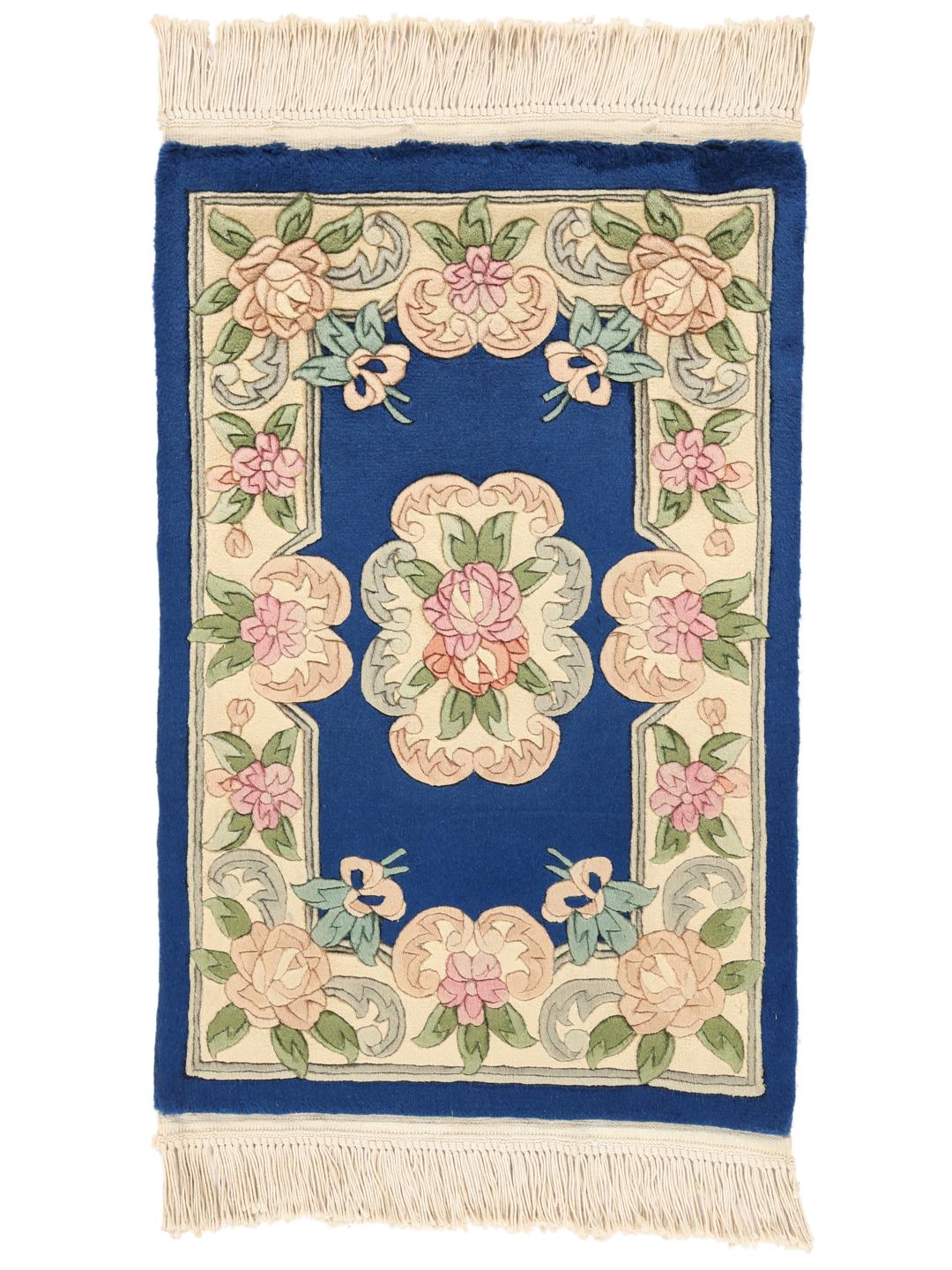 Een handgeknoopt Chinees tapijt met een bloemenpatroon en een blauwe achtergrond.