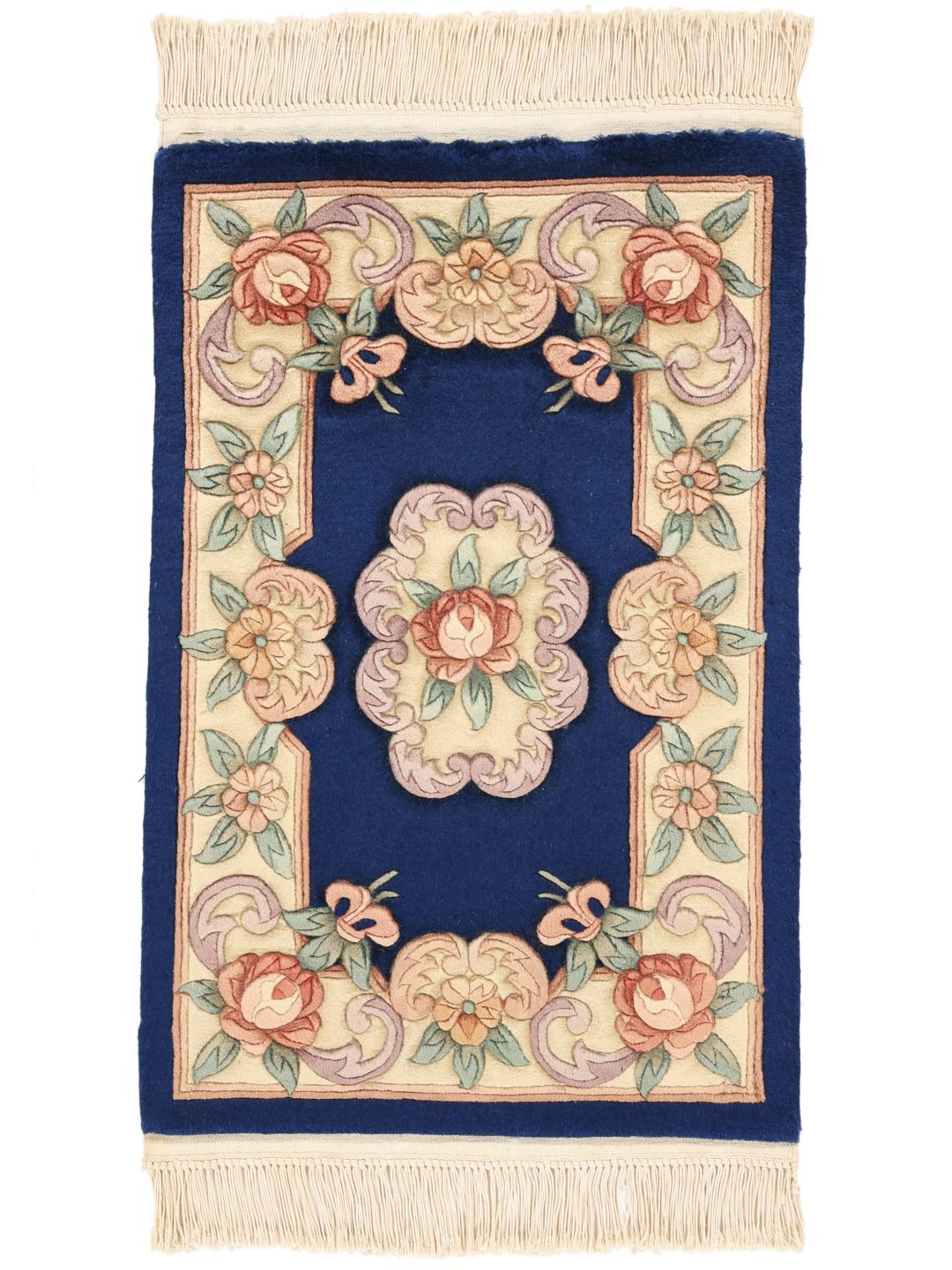 A hand-knotted Chinese rug with floral motifs on a deep blue background.