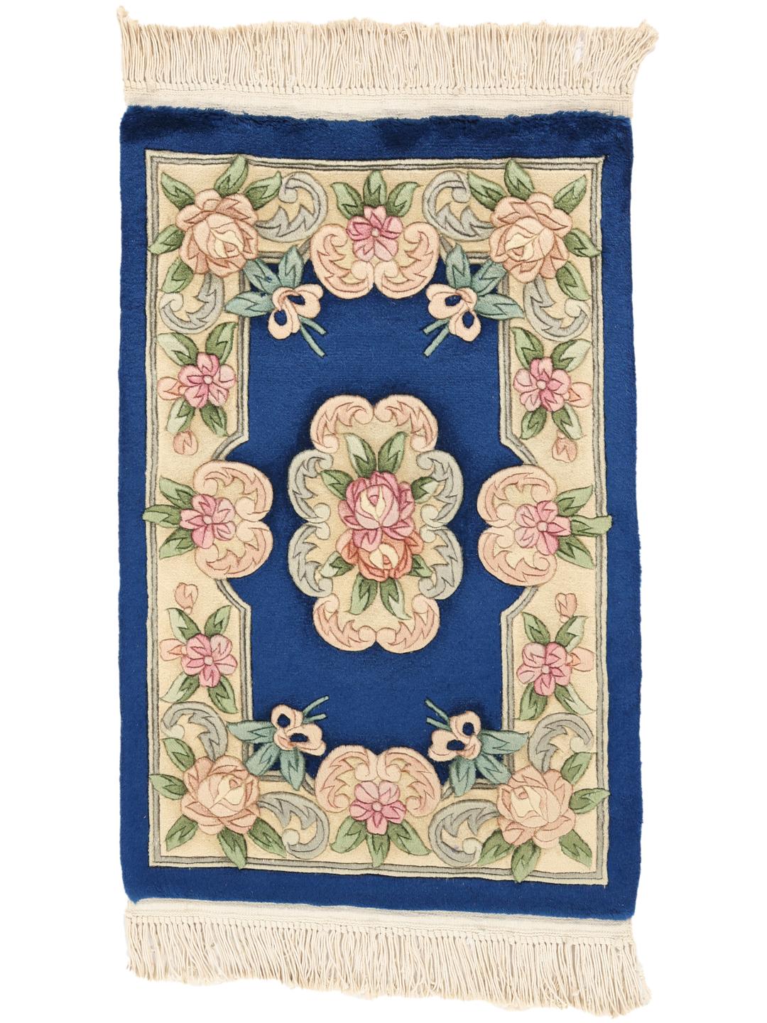 Et håndknyttet rektangulært kinesisk tæppe med blomstermotiver på en dybblå bund