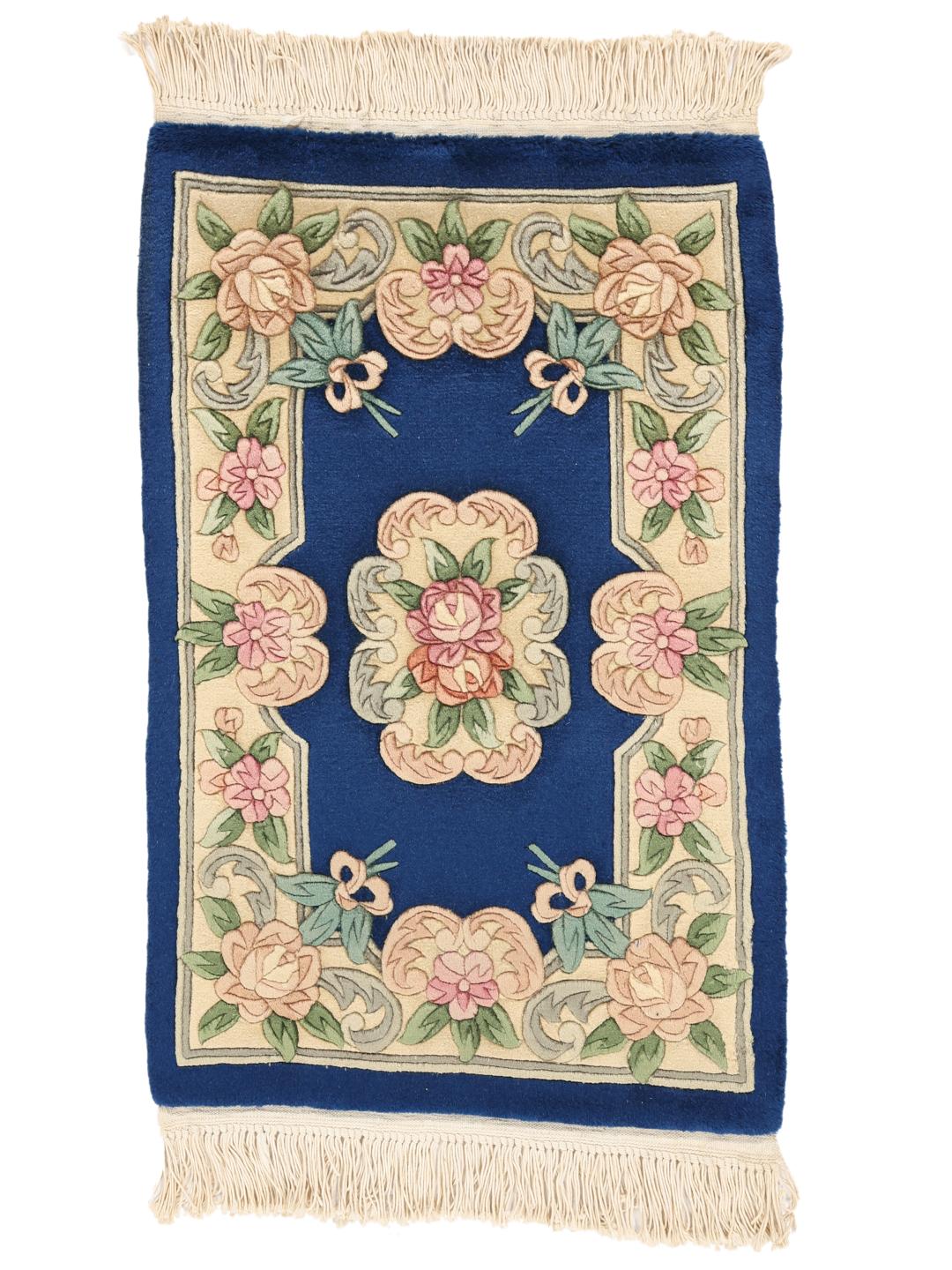 Håndknyttet kinesisk tæppe med blomstermotiver i blå og beige.