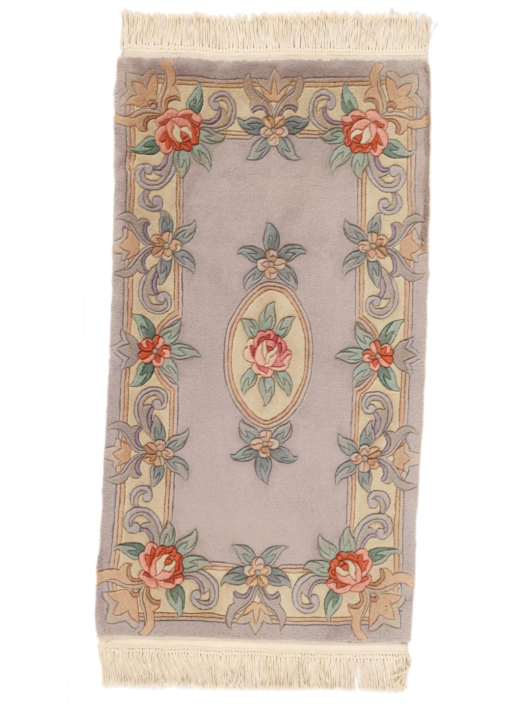 Et håndknyttet kinesisk tæppe med et blomstermedaljon-design i lyseblå og bløde pastelfarver.