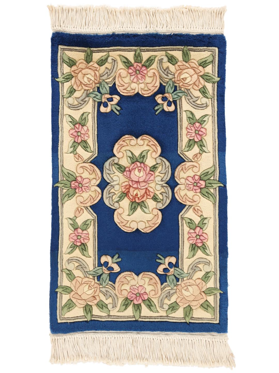 A hand-knotted Chinese rug with a blue field and floral pattern.