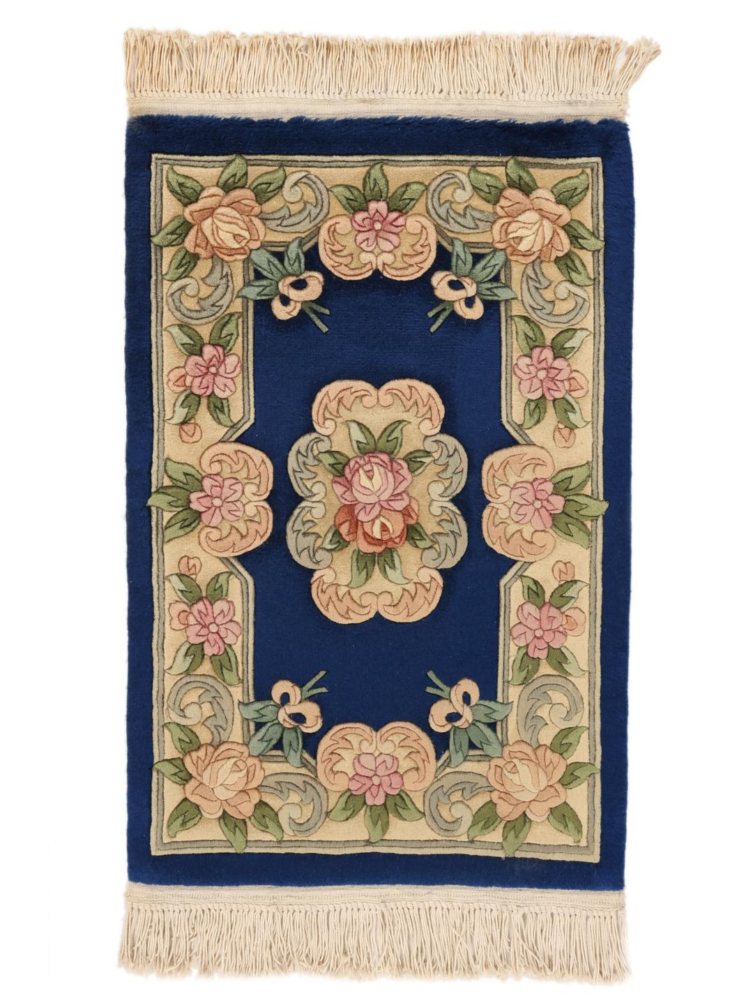 Een handgeknoopt Chinees tapijt met een diepblauw veld en verfijnde bloemmotieven.