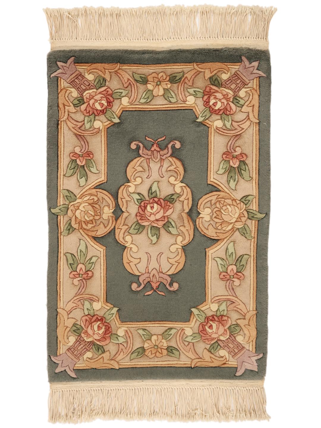 Håndknyttet kinesisk tæppe med et blomstermønster i grønne og beige toner.