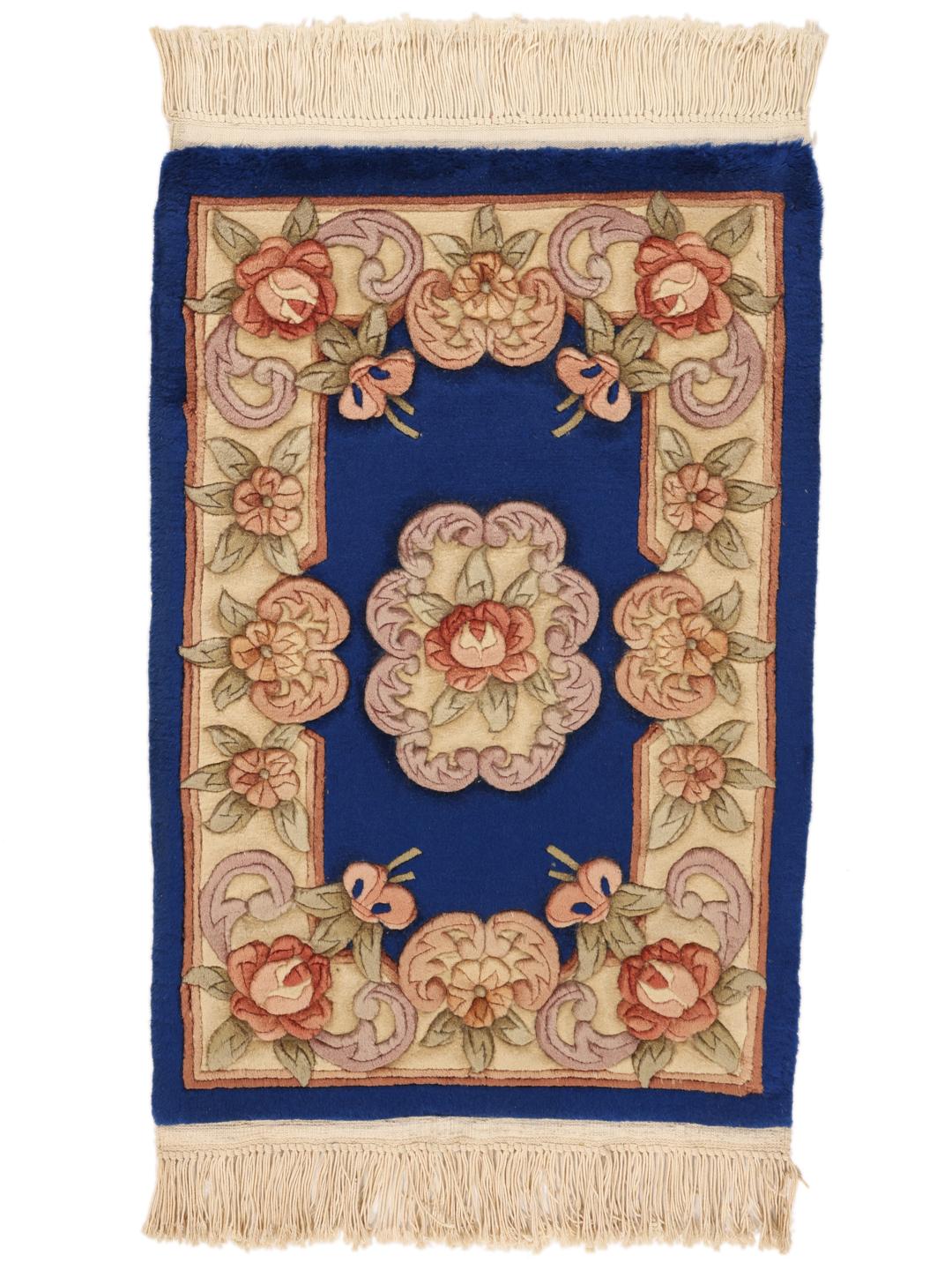 A rectangular hand-knotted rug from China with a blue field and floral pattern.