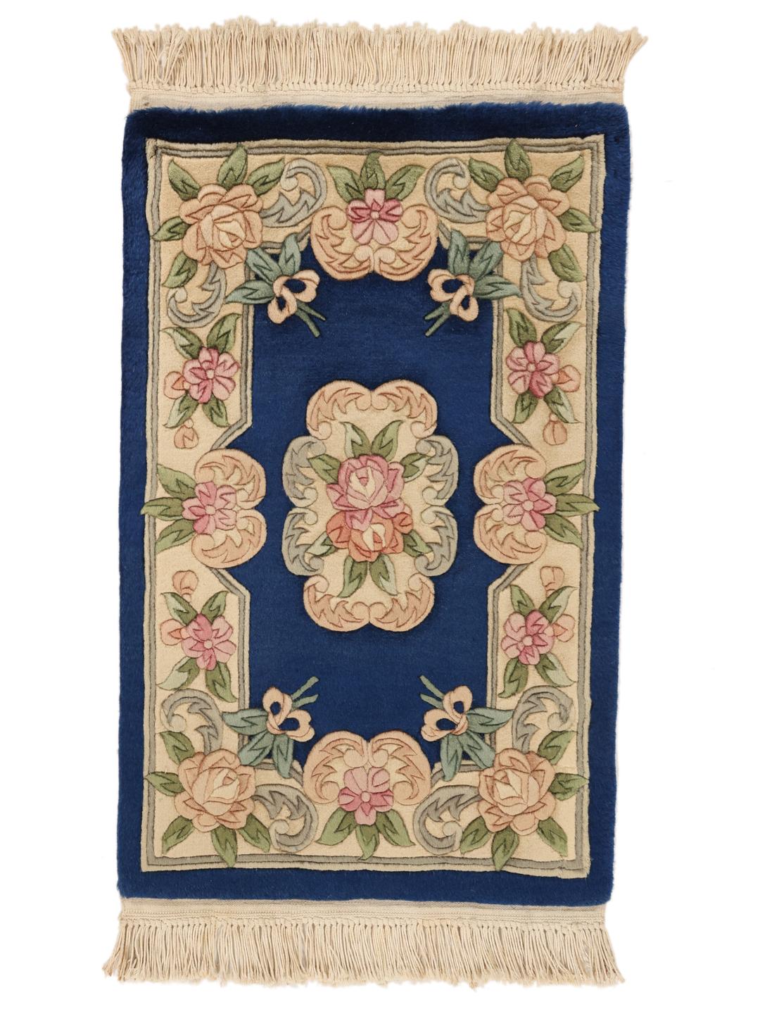 A rectangular Chinese rug featuring a blue field with delicate floral patterns in pink and green.
