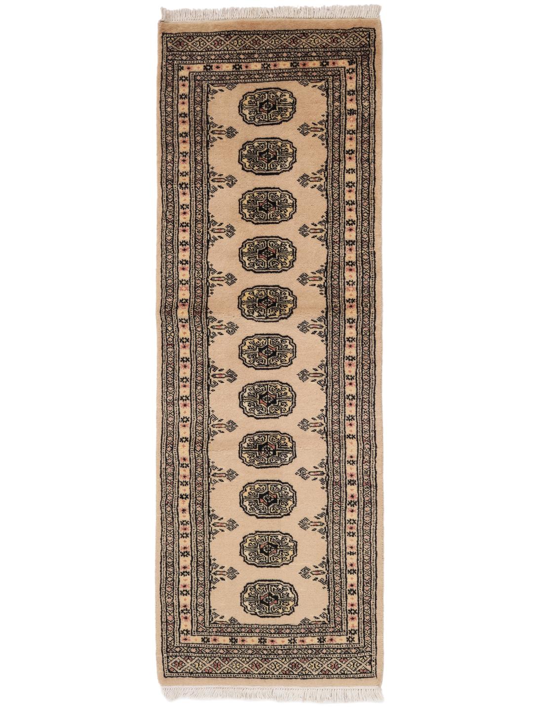 A hand-knotted Pakistan Bokhara runner rug in a soft beige colour with traditional geometric motifs.