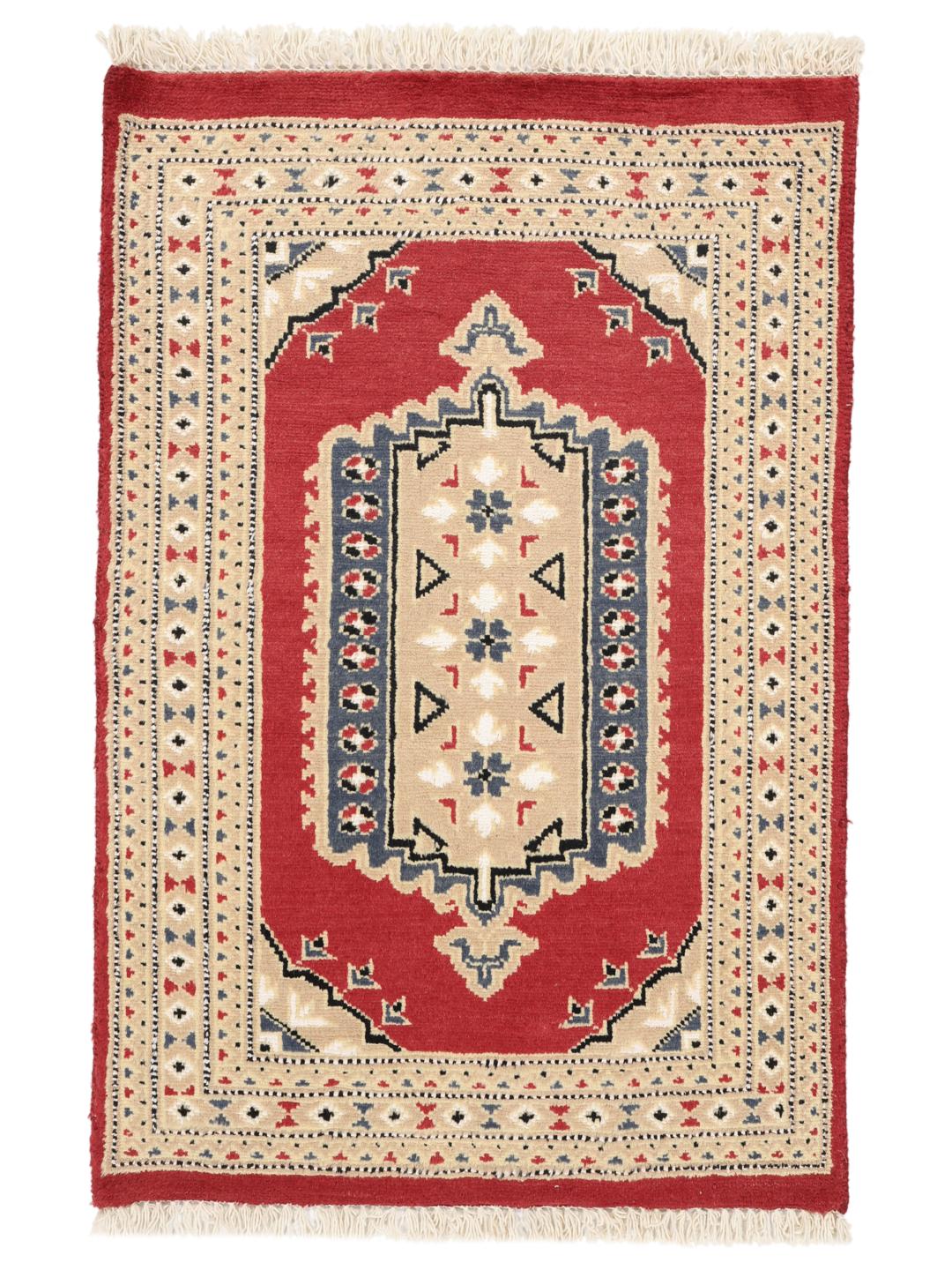 A hand-knotted Pakistan Bokhara rug with a red field and geometric medallion in a home setting.