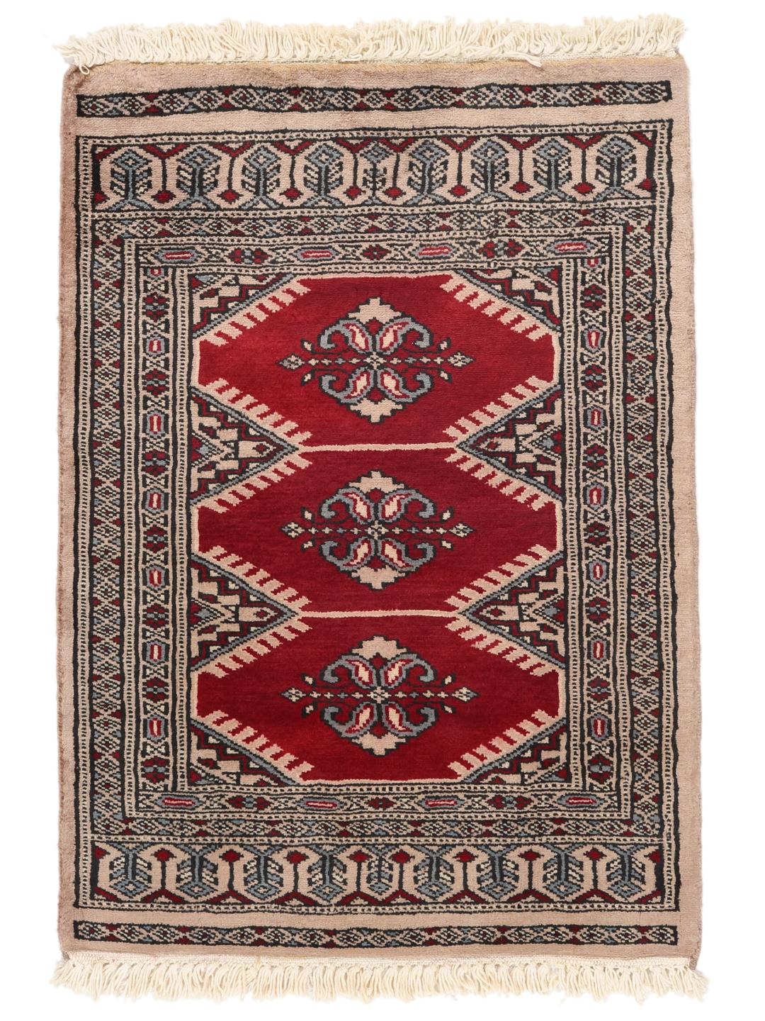 A hand-knotted Pakistan Bokhara rug with a deep red field and intricate geometric medallions.