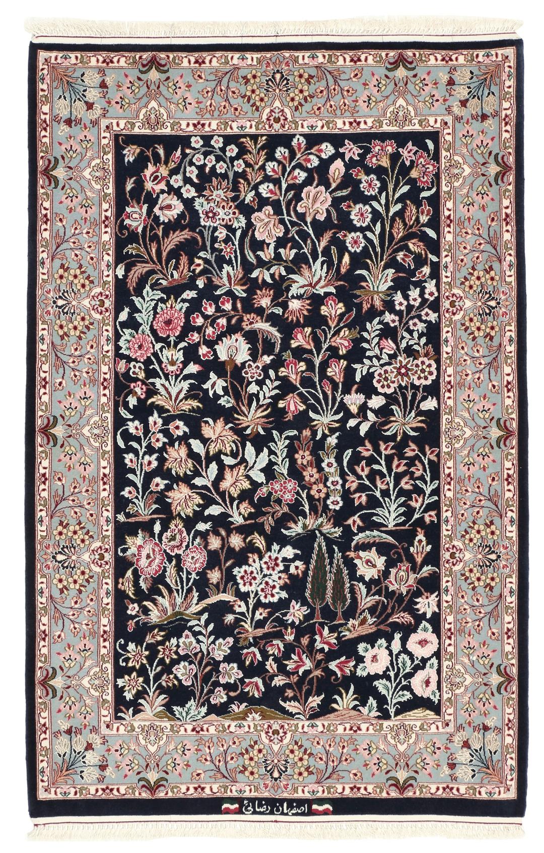 Een met de hand geknoopt Isfahan-tapijt met een ingewikkeld bloempatroon op een donkerblauw veld.