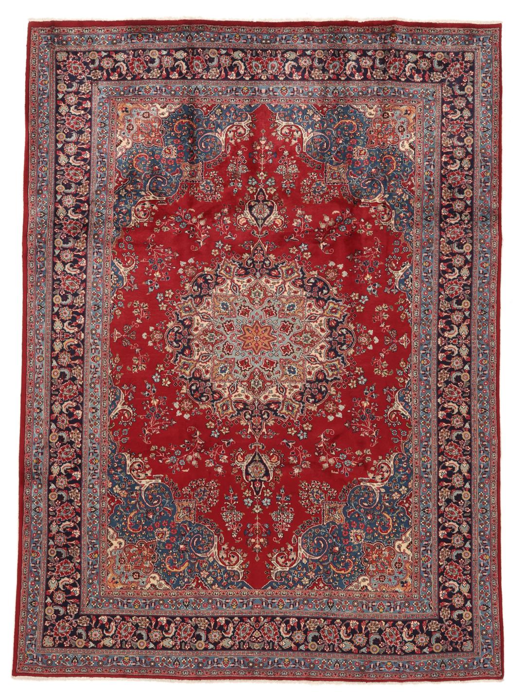 A hand-knotted Mashad rug from the Middle East in deep red and blue tones.
