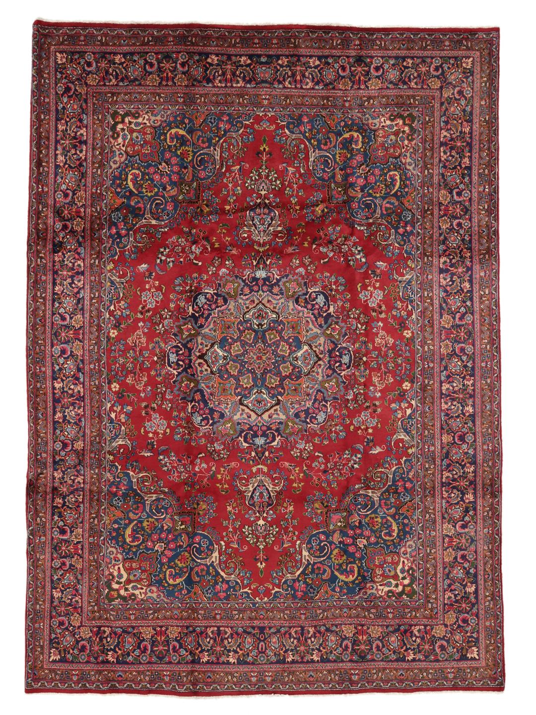 A hand-knotted Mashad rug from the Middle East in shades of red and blue.