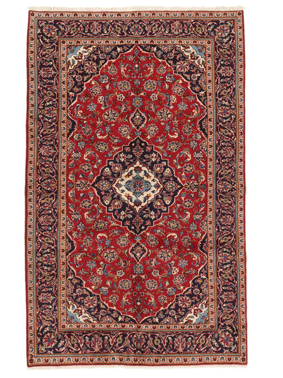 A hand-knotted Middle Eastern Keshan rug with a red and blue floral medallion design.