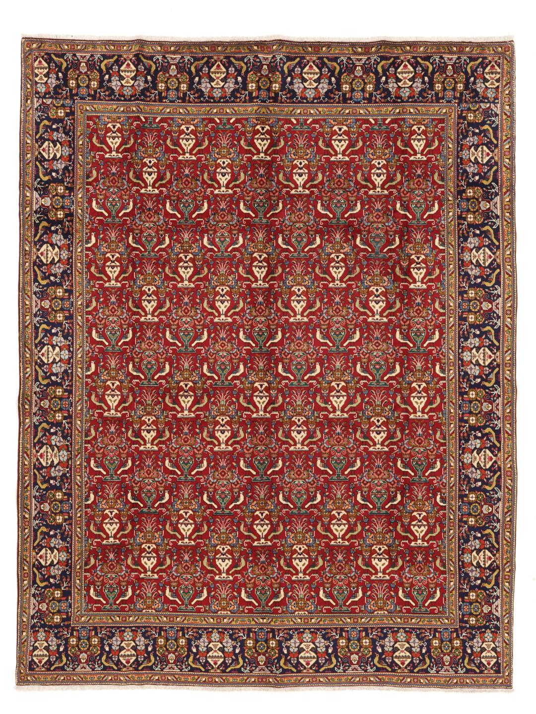 A large rectangular Tabriz rug with a deep red field and intricate floral motifs from the Middle East.