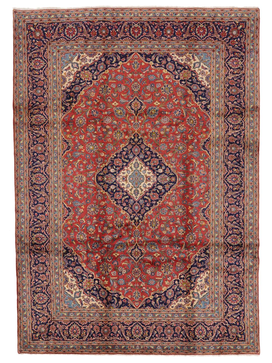 A hand-knotted Keshan rug from the Middle East with a red field and traditional floral motifs.