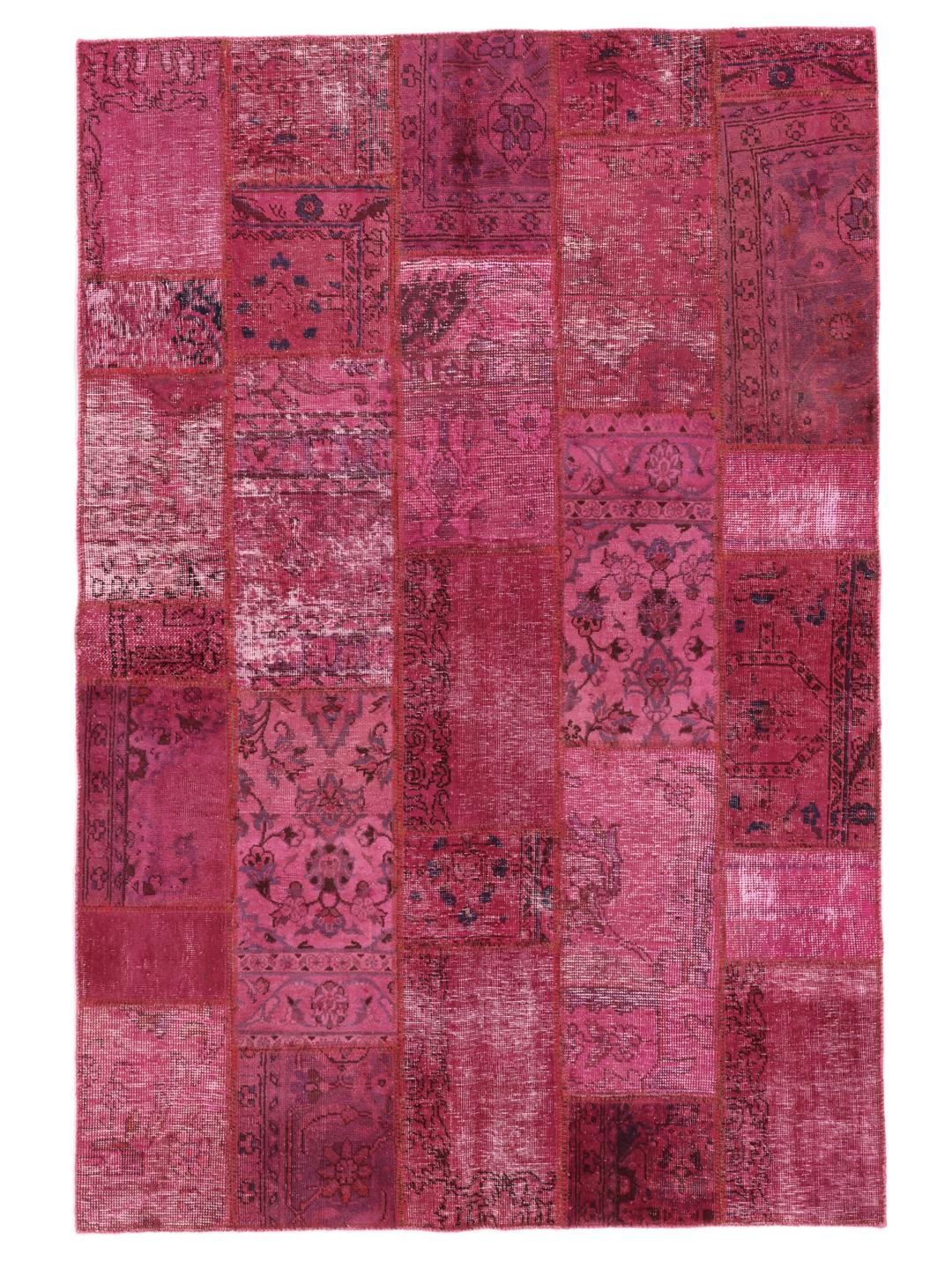 Een levendig roze patchwork tapijt van oorsprong uit het Midden-Oosten met gevarieerde handgeknoopte patronen.