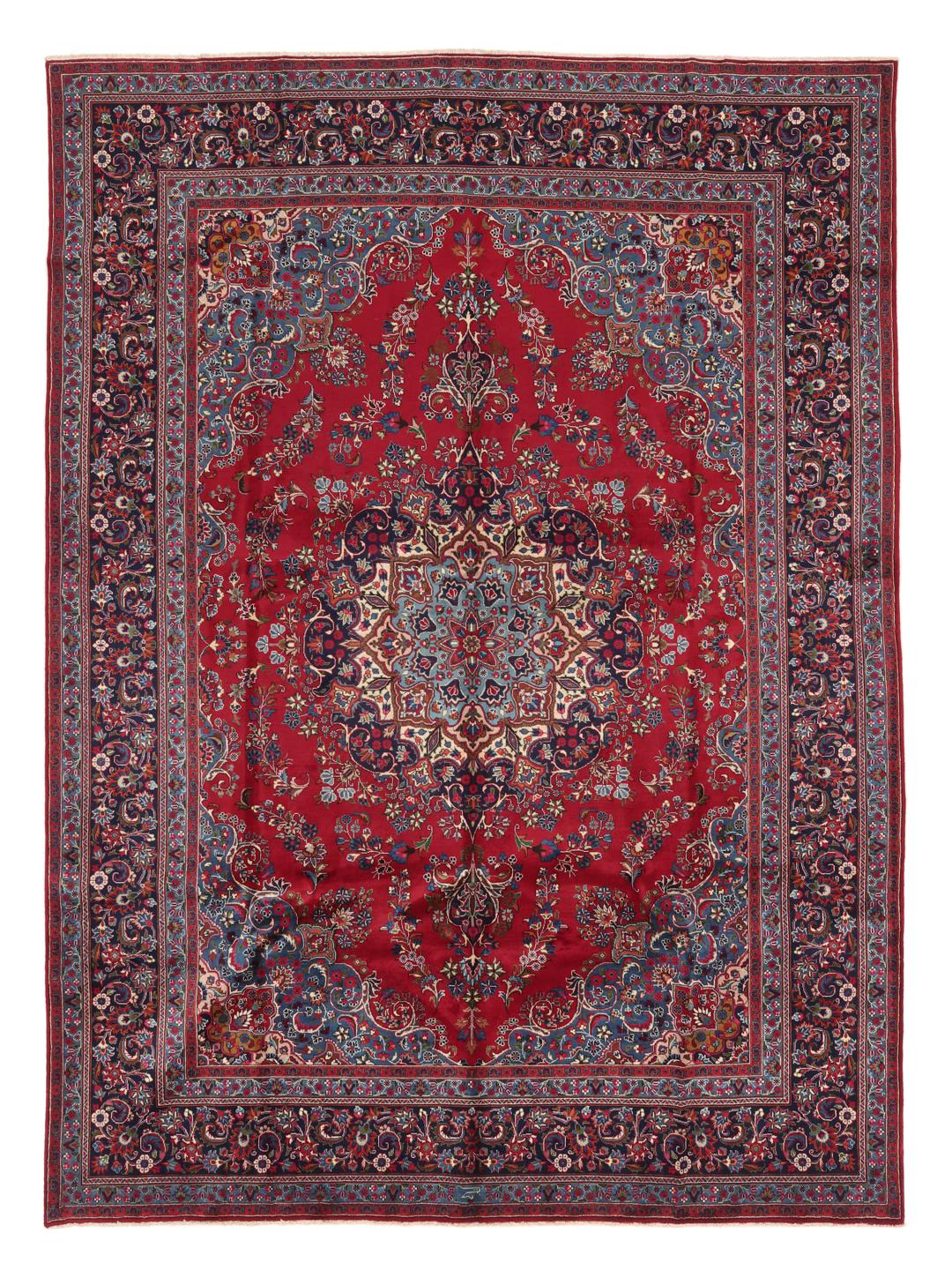 A large, hand-knotted Mashad rug from the Middle East in deep red and blue tones.