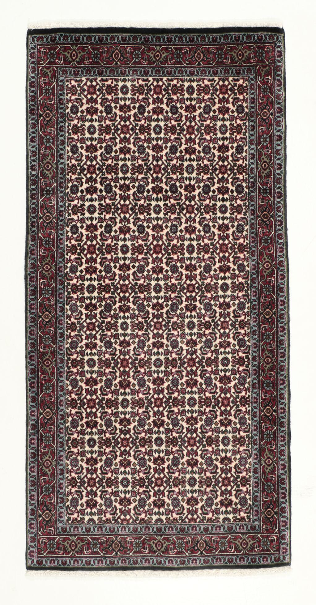 Een handgeknoopt Bidjar-tapijt uit het Midden-Oosten met een donkerrood en beige bloemenpatroon.