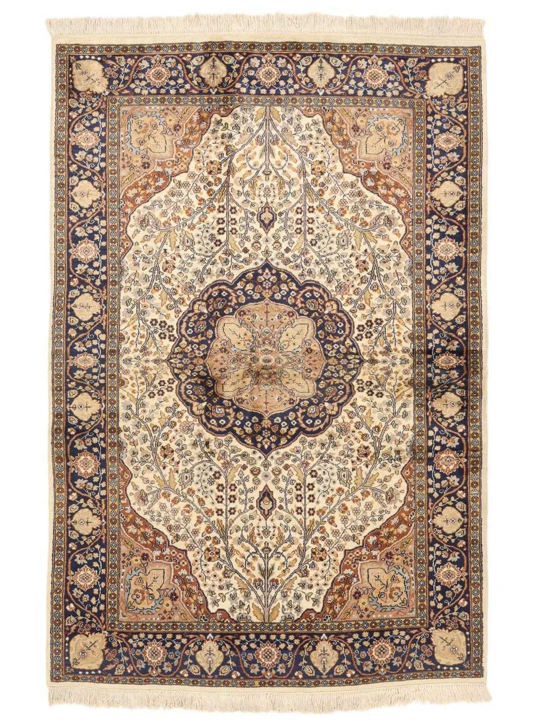 Et håndknyttet indisk tæppe med et blåt og cremefarvet blomstermedallion-design.