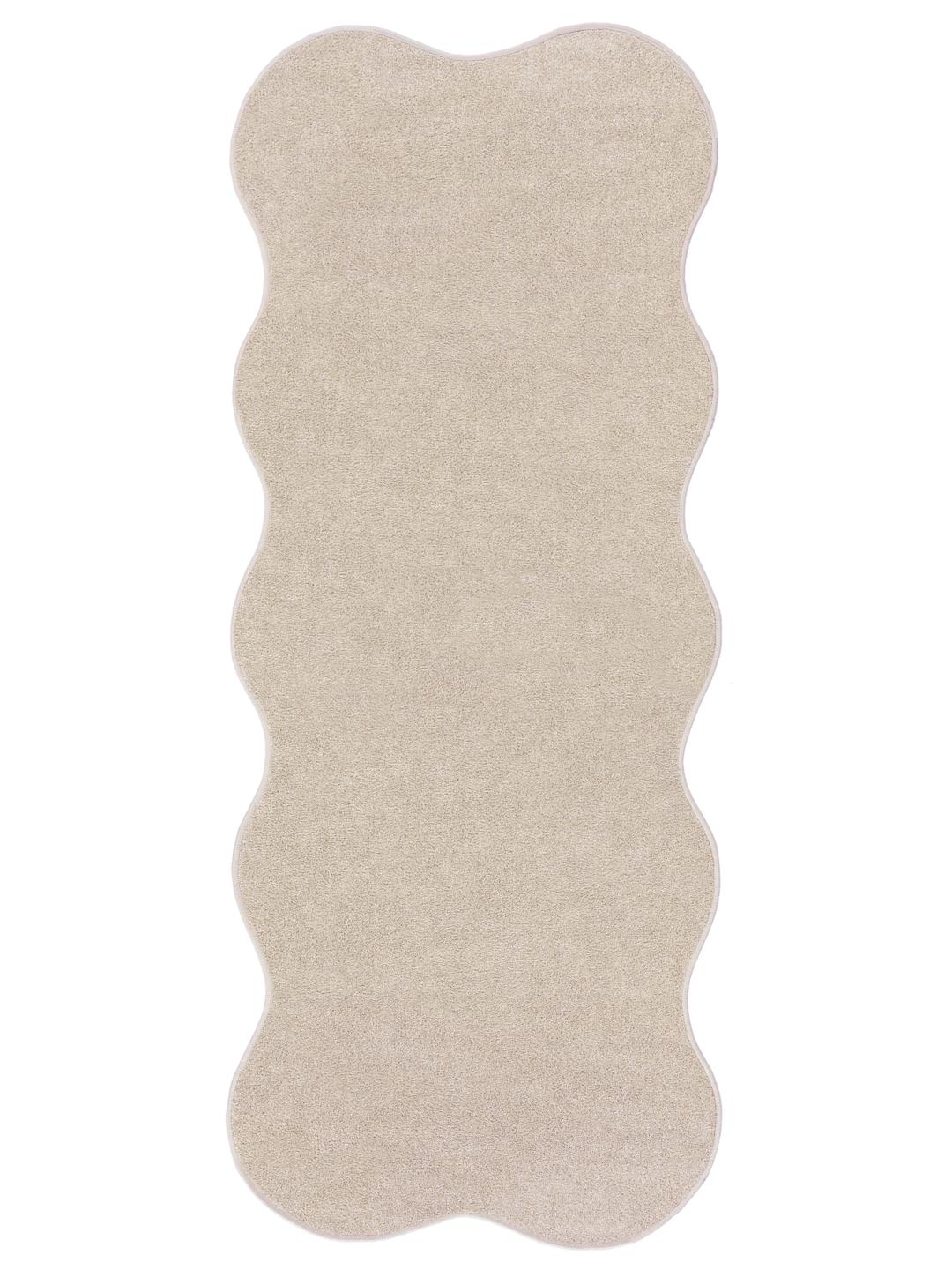 Beige tæppe med en uregelmæssig form og blød luv.