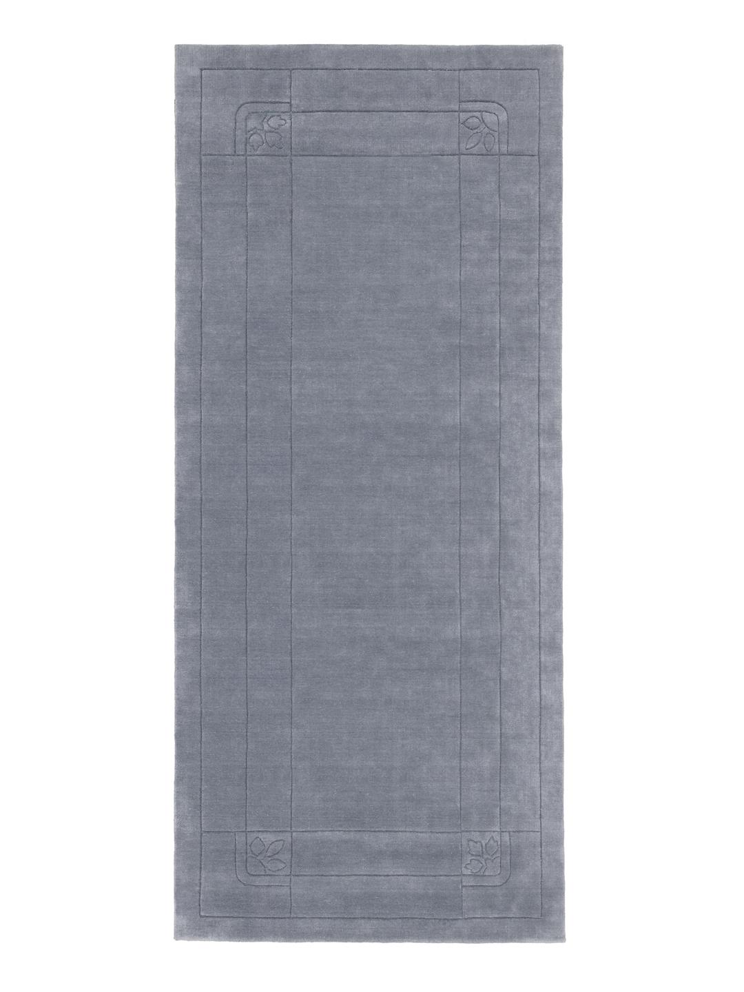 En rektangulær blå løber med en subtil bladkantdetalje på en ensfarvet baggrund.