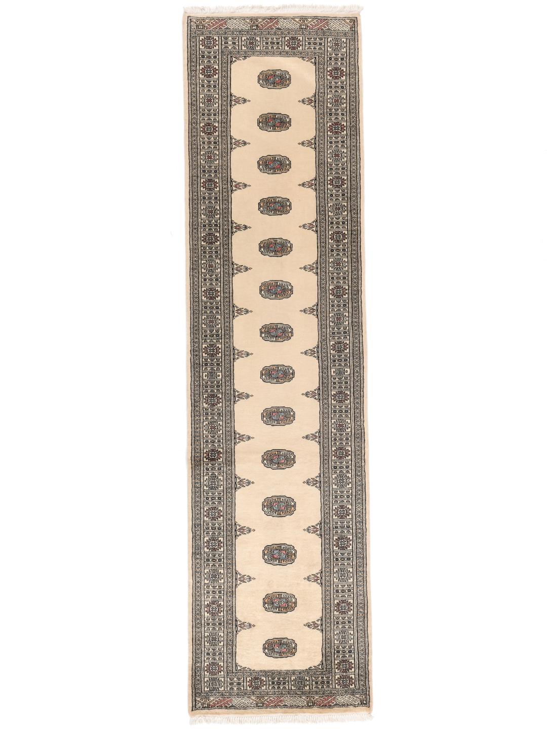A hand-knotted beige runner from Pakistan with traditional patterns.