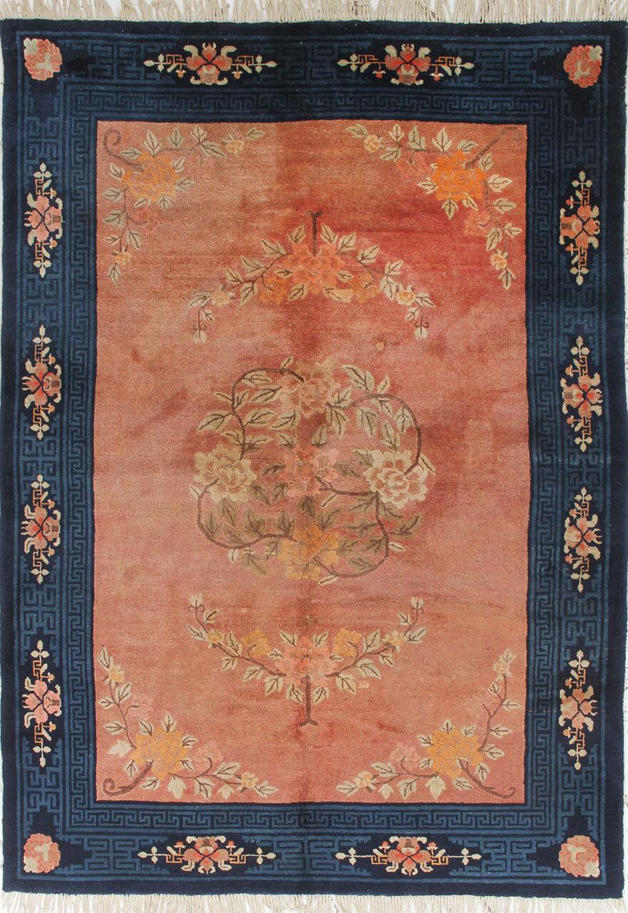 Een prachtig antiek tapijt uit China met een rood veld en bloempatronen.