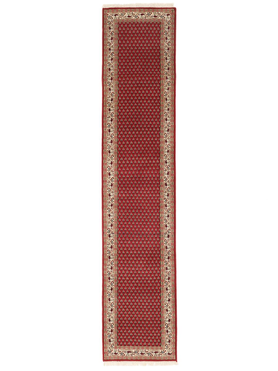 Un long tapis de couloir Mir Indo noué à la main, originaire d'Inde, avec un champ rouge profond et un motif floral complexe.