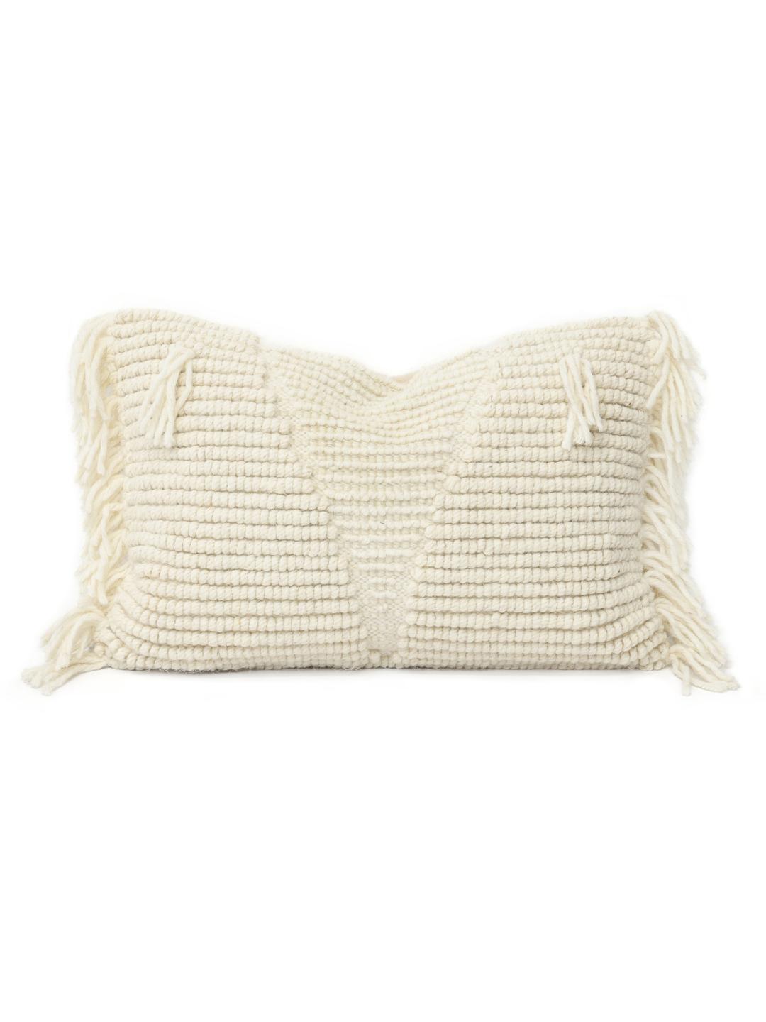Witte kussenhoes met een handgeweven wollen textuur en franjes.