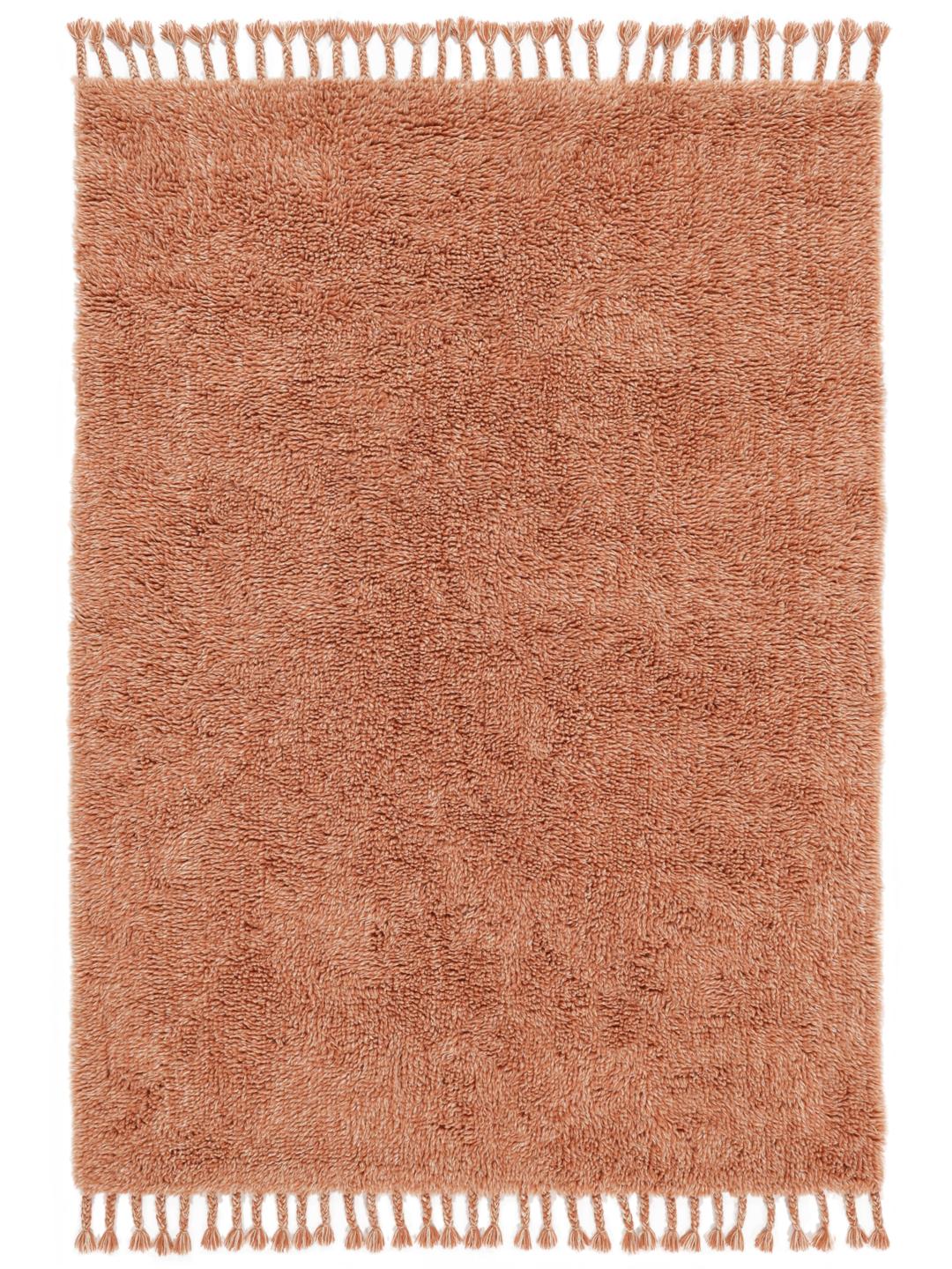Een zacht terracotta shaggy kleed met franjes